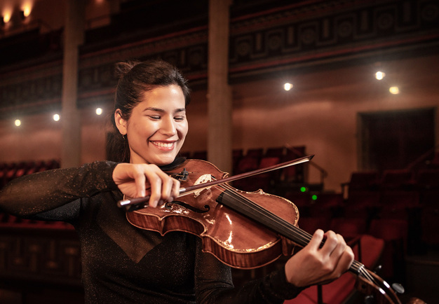 Kvinna som spela violin. Fotografi.