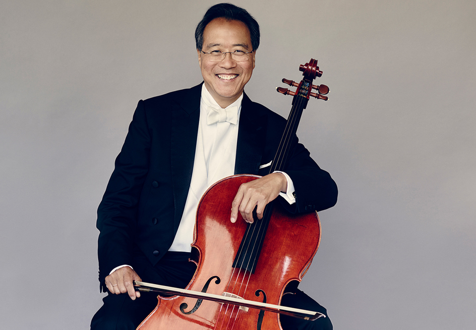 Man sitting with his cello. Photo.