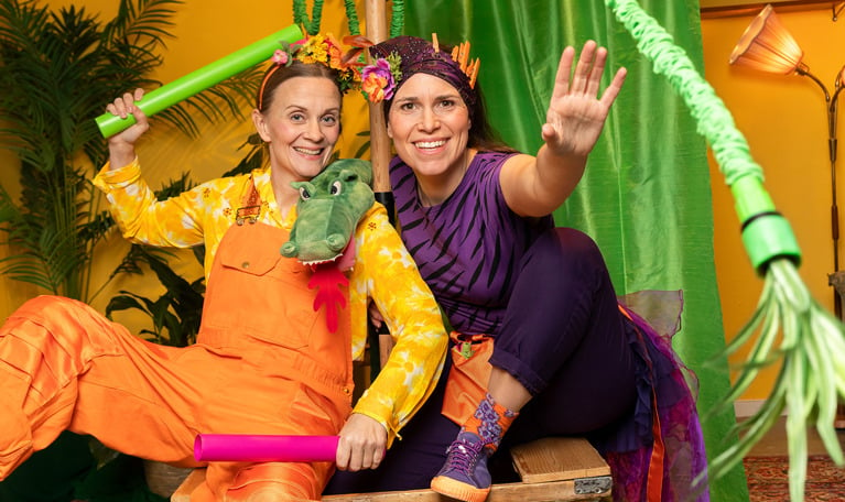 Två glada damer med färgglada kläder. Fotografi. 