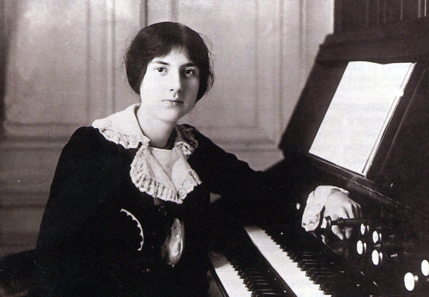 Svartvitt foto av kvinna som sitter vid ett piano.