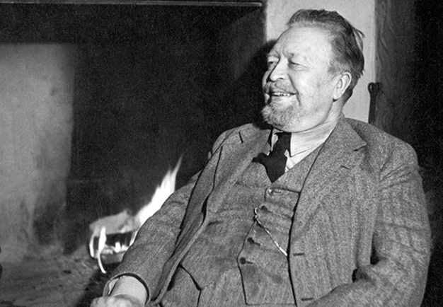 Gammal svart vit bild av sittande och glad tonsättare. Wilhelm Peterson-Berger. Fotografi.