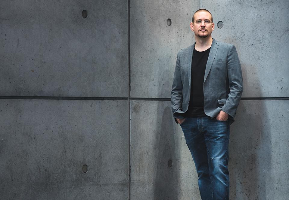 Man leaning against a wall. Photo.